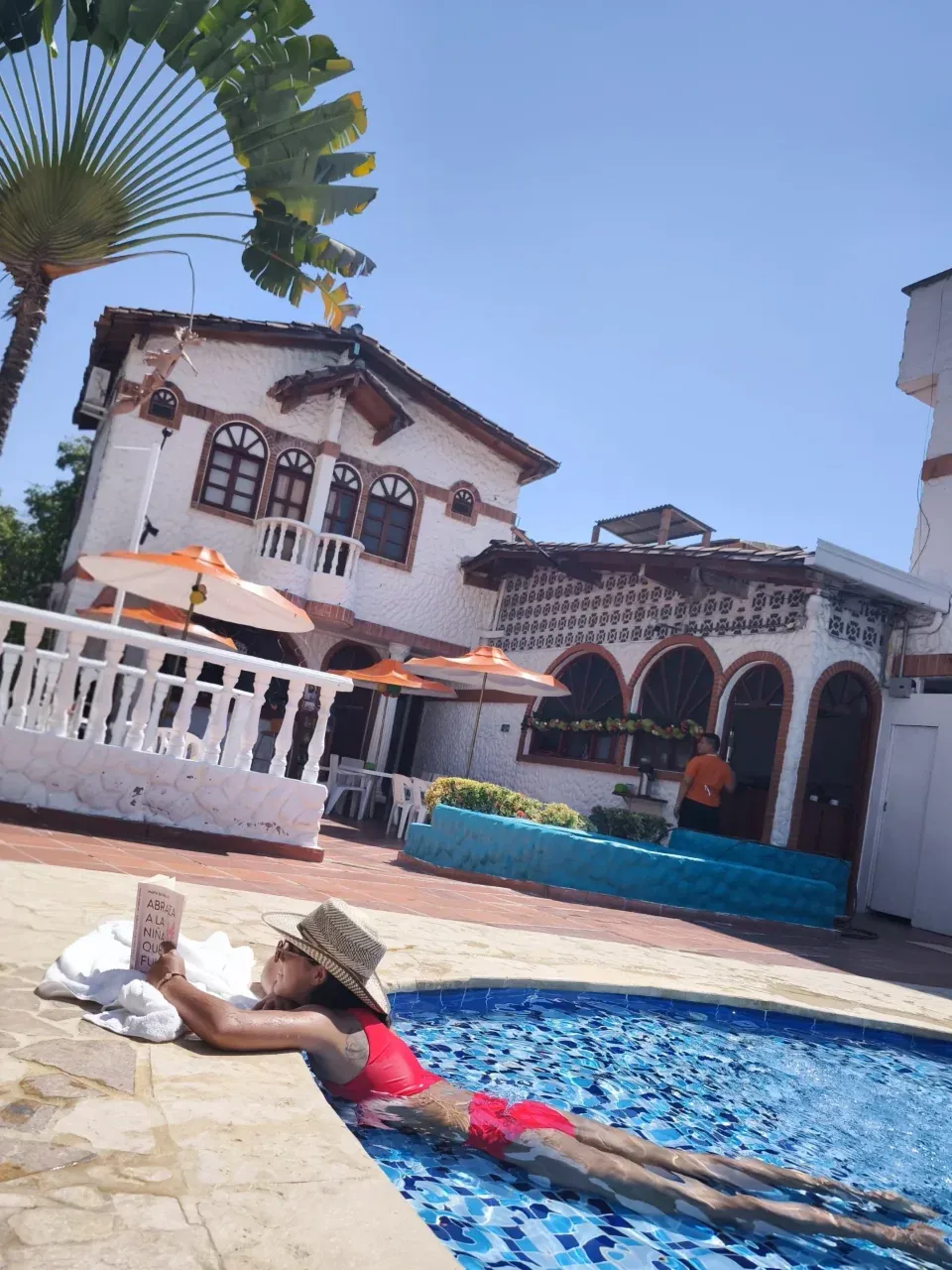 Fachada colonial blanca junto a la piscina
