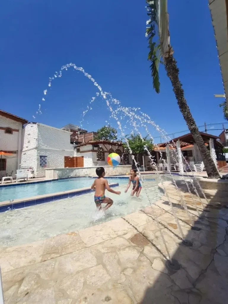 Niños jugando en la fuente de la piscina