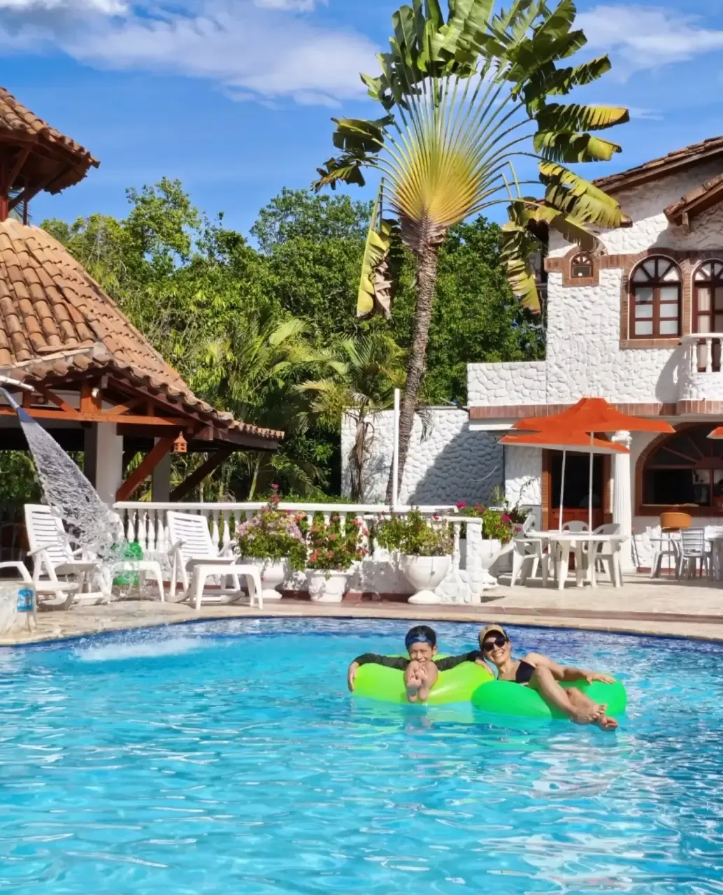 Piscina de la hostería con kiosco y fachada colonial